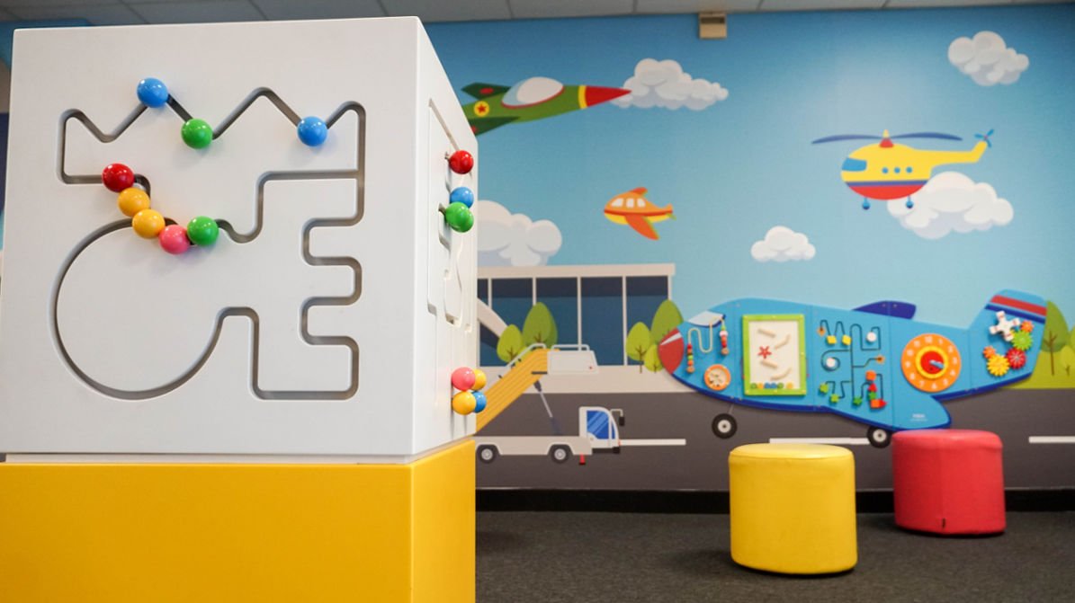 Childrens play area at London Luton Airport with aeroplane toy visible on wall