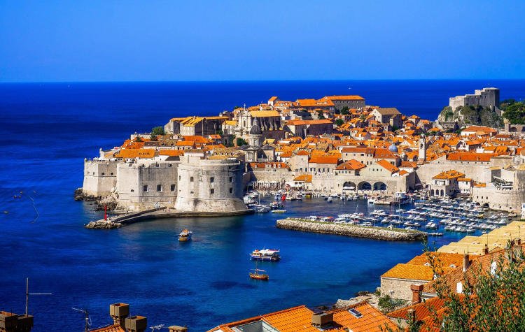 Walled city of Dubrovnik surrounded by blue waters